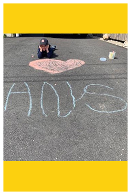Student laying next to HNS chalk drawing outside