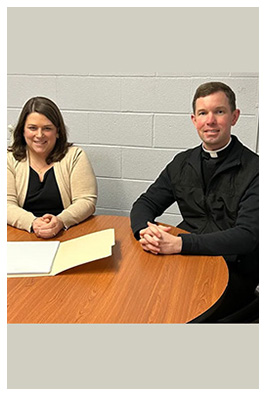 Fr. Riley J. Williams, Pastor and another adult sitting at a table